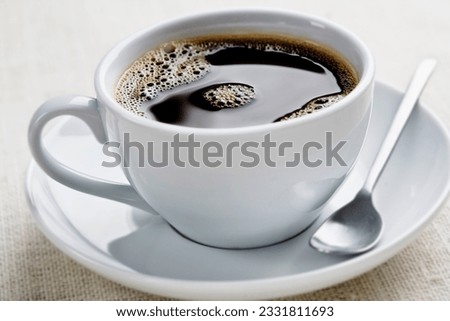 cup of freshly brewed black coffee, focus is on the middle bubbles