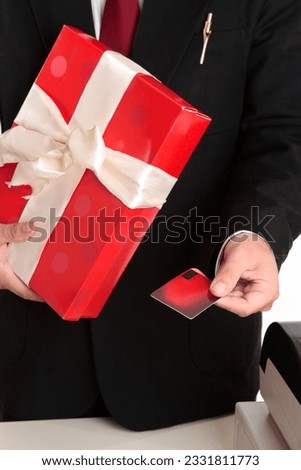 Man makes a christmas or other special occasion purchase with a gift card or credit debit card. Focus to hand, shallof dof.