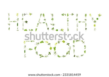 Large selection of herb leaf sprigs, spelling the words healthy food, over white background.