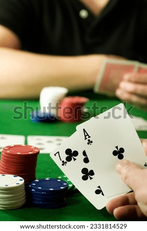 People playing Texas hold -em Poker around a gambling table.