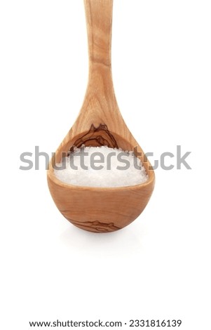 Sea salt in an olive wood ladle over white background.