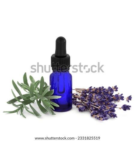 Lavender herb dried flowers and leaf sprig with an aromatherapy essential oil glass blue bottle, over white background.