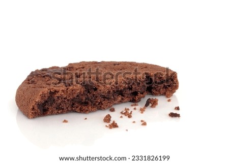Chocolate chip cookie with a bite taken out and loose crumbs, isolated over white background.