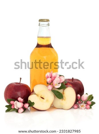 Cider bottle with red apples whole and in half with apple flower blossom, isolated over white background.