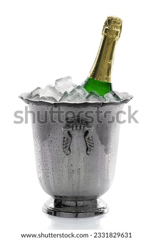 Cold bottle of champagne on ice with white background
