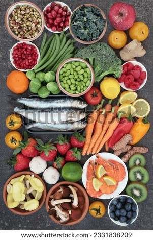 Healthy food for good health concept with super food of sardines, crevettes, fruit, vegetables, herbs and spice. Foods very high in antioxidants, anthocyanins, omega 3 fatty acids, fiber and vitamins.