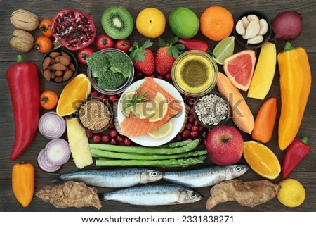 Health food for a healthy heart concept with fresh sardines, salmon, vegetables, fruit, nuts, seeds, herbs and olive oil. Superfood high in omega 3 fatty acid, anthocyanins, antioxidants, minerals and