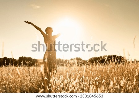 Joyful Person Raising Arms morning  in Rural Field Under Summer Sunlight Royalty-Free Stock Photo #2331845653