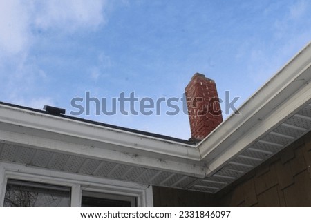 A brick chimney sits on top of a roof in rural Alberta.