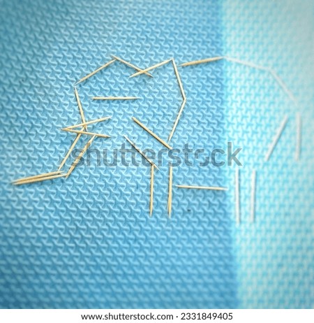 a picture of an elephant from a bamboo toothpick on a blue floor.