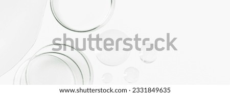 Petri dishes, flasks, test tubes. On a light background. Drops and smears of transparent gel. Laboratory. Banner. empty space for advertising