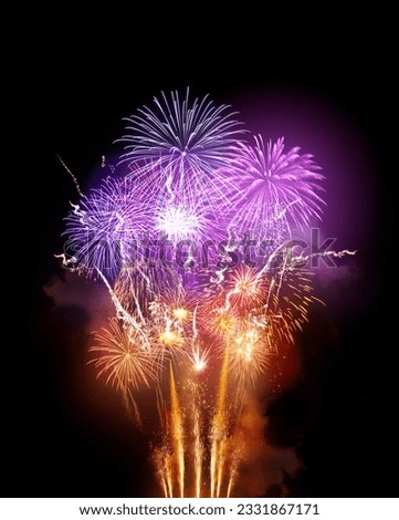 A large bright fireworks display event with golden orange and purple rocket breaks.