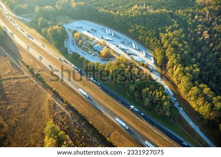Aerial view of big rest area near busy american freeway with fast moving cars and trucks. Recreational place during interstate travel concept Royalty-Free Stock Photo #2331927075