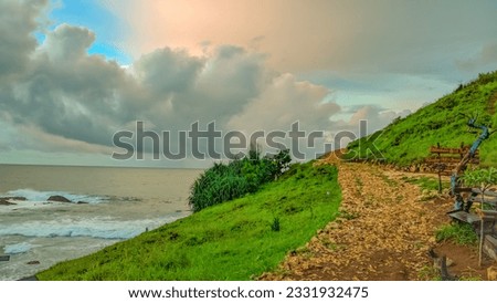 Beautiful scenery landscape seascape rocky road on hill Kasap beach in Pacitan East Java Indonesia. Cloudy sky rainy season tropical climate. Vacation illustration copy space