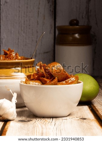 Andhra traditional home made Totapuri raw mango sweet and spicy  pickle on a rustic wooden table  background- Selective focus
