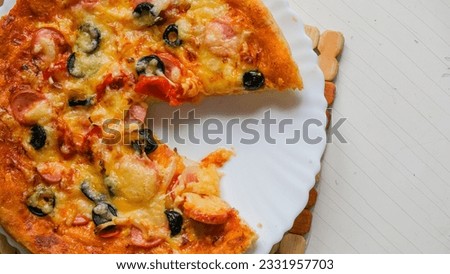 Homemade pizza on a plate. Cut off a piece of pizza.