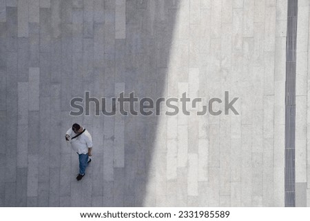 top aerial view man people walk on across pedestrian concrete with black silhouette shadow on ground, concept of social still life.