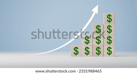 Wooden blocks with US dollars. concept of revenue growth. growth on stacked wooden cubes on blue background. arrow and dollar icons on wooden cubes. dollar issue. copy space