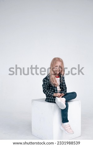 A series of casual-style photographs features a girl with light hair wearing a plaid shirt and jeans. The images capture her relaxed and effortless charm, embodying a laid-back and fashionable vibe.