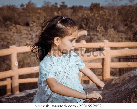 Cute child present editing filter effect of portrait image. Little girl clear face focusing at camera. Dress wearing black and white. Glorious look with close up hand style behind blur background.