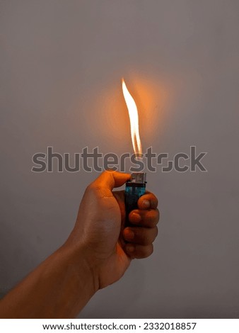 male hand holding a burning match lighter Royalty-Free Stock Photo #2332018857