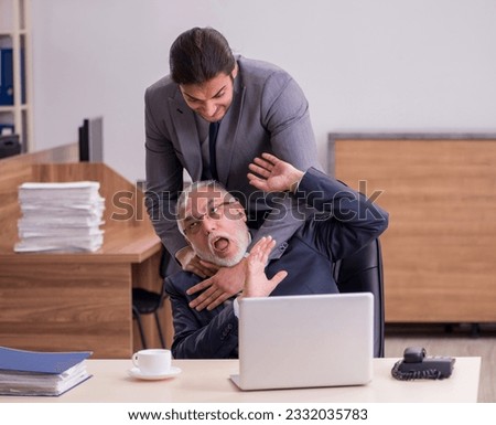 Old boss and young male assistant in the office Royalty-Free Stock Photo #2332035783