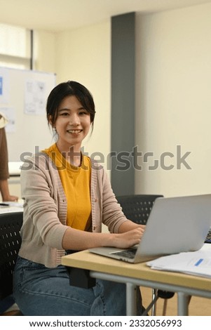 Portrait of pretty young asian woman developer woman working on app design and user interface at workstation