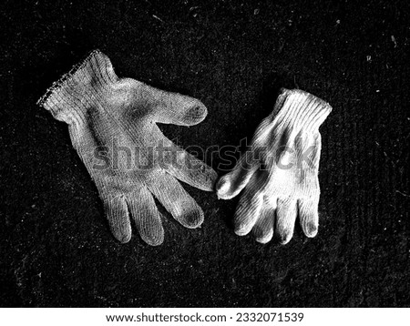 Picture 1 pair of used gloves that have been used all day at work and edited to black and white