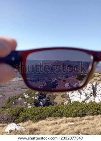 View of beautiful mountains watched through plastic sun glasses