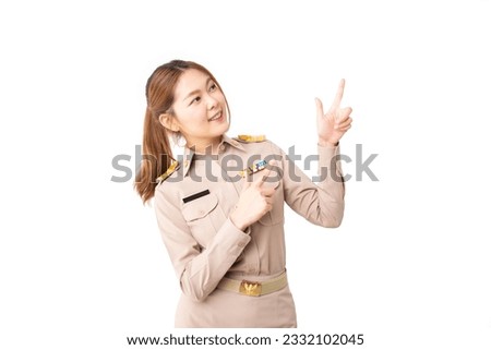Female Thai government officer in khaki uniforms looking above and pointing up to product or empty copy space isolated white background. advertising, presenting, promotion, satisfied product concept.