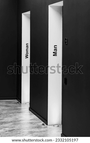 Perspective of a long corridor in office building. Doors of washrooms in hallway. Doors office with wc signs. Entrance to restrooms in a factory