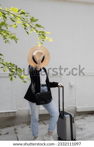 young happy brunette girl in sunglasses and straw hat with a suitcase, vacation