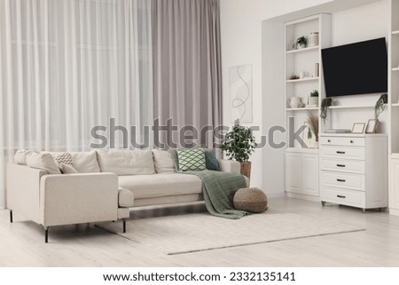 Stylish living room interior with comfortable sofa, TV set and houseplant Royalty-Free Stock Photo #2332135141