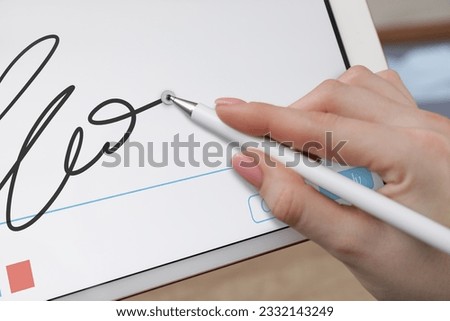 Electronic signature. Woman using stylus and tablet, closeup