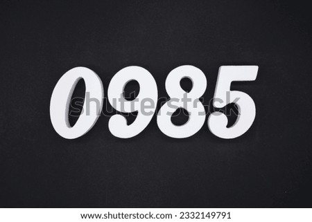 Black for the background. The number 0985 is made of white painted wood.
