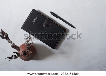 selective focus of black notebook and pen in white background 