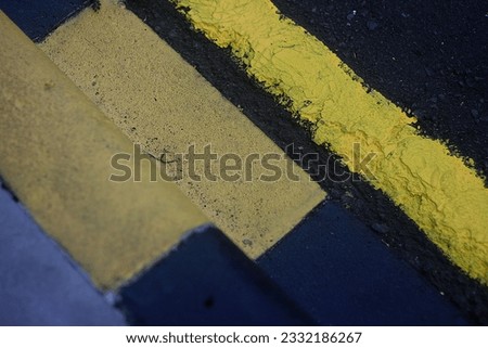 yellow road lines and yellow black sidewalk squares