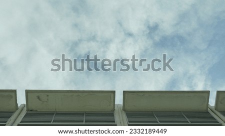 a skyscraper with a cloudy sky in the background.