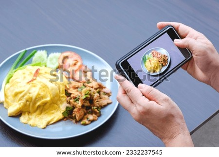 Woman hands using smartphone to taking photo of Asian street food on wooden table