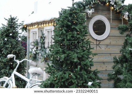 Christmas porch decoration idea. House entrance and window sill decorated for holidays. New year winter front yard festive snow tree garlands on facade