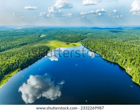Aerial Imagery with small lakes, forest and beautiful blue sky with big puffy clouds in Summertime. 