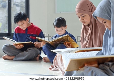 Group of muslim children reading Koran or Quran together at the mosque during Ramadan. Selective focus.  Royalty-Free Stock Photo #2332298953