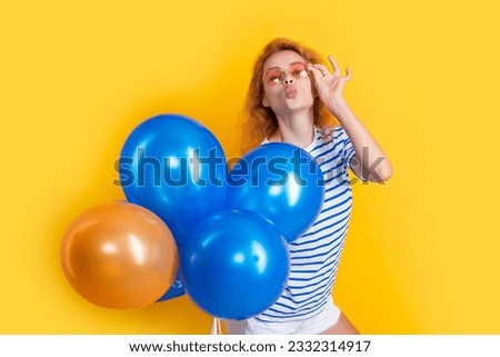 party girl with balloon in sunglasses. happy young girl hold party balloons in studio.