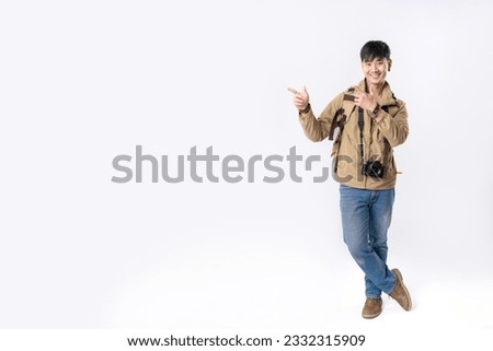 Full length of traveler handsome asian man pointing out to present something, the smile on his face, his hand gesture and the casual outfit are perfect for the suggestion to copy space.