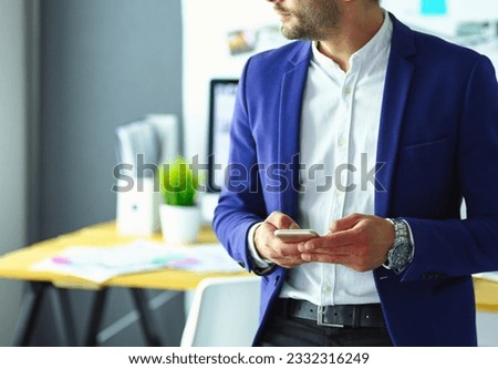 Portrait of young designer in front of laptop and computer while working.