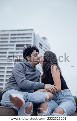 Picture of loving couple in a park with buildings behind in Lima, Peru. Lifestyle and couples concept.