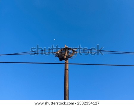 a small electric pole photographed against a blue sky background