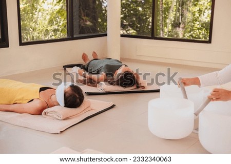 Music Therapy Session in Thailand. Sound Meditation, body healing. Seven chakras. Sunny room with 3 people meditating. Healthcare recreation process Royalty-Free Stock Photo #2332340063