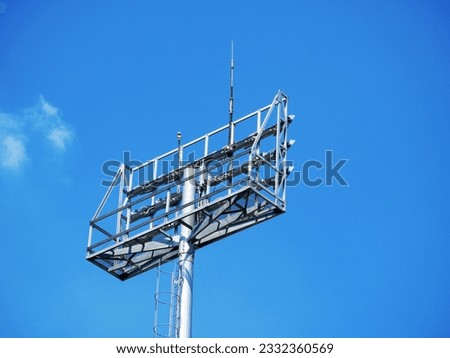view of lamp post, electric industry, light stadium or sport lighting isolated on blue background. little white cloud