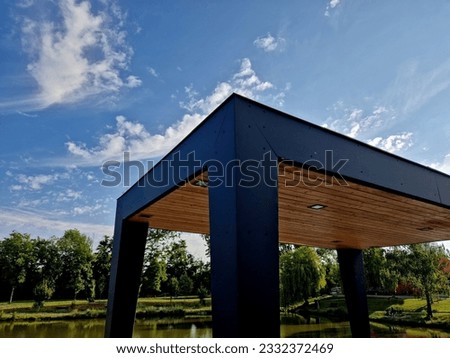 terrace with pergola sheet metal, strong columns made of sheet metal. the ceiling is lined with wood. led light is located in the ceiling soffit. location high above the lake, near the house Royalty-Free Stock Photo #2332372469
